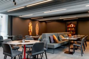 a restaurant with tables and chairs and a couch at Radius Hotel Tbilisi in Tbilisi City