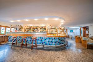 a bar with stools in front of a blue tile counter at Hotel Continental Ischia in Ischia