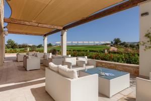 a patio with white chairs and a blue table at Aphrodite Hills Rentals - Apartments in Kouklia