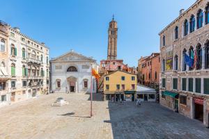 una calle de la ciudad con una torre de reloj en la distancia en La Dimora di San Maurizio 1- Dimora Italia -, en Venecia