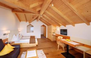 a hotel room with a bed and a desk at Small Hotel Sonne in Tirolo