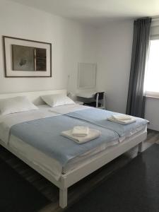 a bedroom with a large bed with two towels on it at Apartment Romeo in Crikvenica