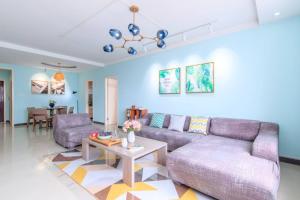 a living room with a purple couch and a table at Baoding Jingxiu·Beiguo Shopping Mall· in Baoding