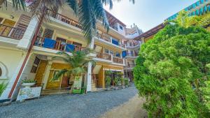 an empty street in front of a building with palm trees at Sky Garden Mini Hotel in Mirissa