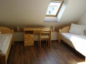 Habitación con 2 camas, escritorio y ventana. en Hotel Alt Vinnhorst en Hannover