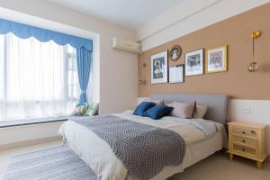 a bedroom with a large bed and a window at Haikou Xiuying·Binhai Avenue· Locals Apartment 00164510 in Changliu +28 photos