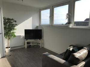 a living room with a couch and a flat screen tv at Carvetii - Edward House C - 2 Dbl bed 2nd floor flat in Dunfermline