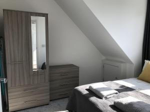 a bedroom with a bed and a dresser with a mirror at Carvetii - Edward House C - 2 Dbl bed 2nd floor flat in Dunfermline