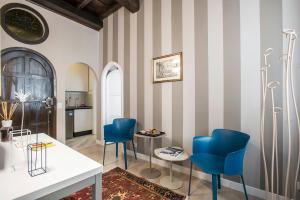 a living room with striped walls and blue chairs at La Finestra su Fontana di Trevi - Charming View in Rome