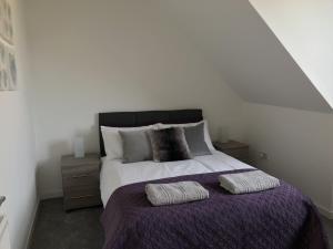 a bedroom with a large bed with two pillows at Carvetii - Edward House C - 2 Dbl bed 2nd floor flat in Dunfermline