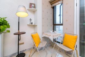 a small table and chairs in a room with a window at LuoYang Xigong·Shenglong Square· in Luoyang