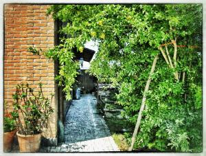 a garden with an archway with plants and a brick wall at La Corte del Macero in Castelfranco Emilia