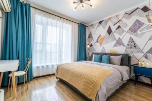 sypialnia z łóżkiem z niebieskimi zasłonami i biurkiem w obiekcie Zhengzhou Jinshui · North 3rd Ring Huayuan Road·Locals Apartment · 00174560 w mieście Zhengzhou