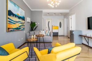 a living room with yellow chairs and a couch at Zhengzhou Jinshui · North 3rd Ring Huayuan Road·Locals Apartment · 00174560 in Zhengzhou
