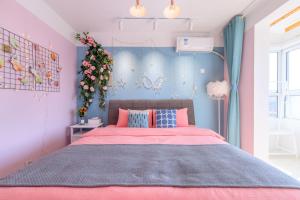 a bedroom with a large bed with pink and blue walls at Baoding Lianchi·North China Electric Power University· in Baoding
