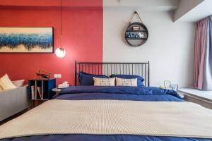 een slaapkamer met een blauw bed en een rode muur bij Zhengzhou Huiji·Huijiwanda in Zhengzhou