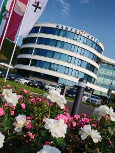 un edificio con una bandera y flores delante de él en Hanse Hotel Attendorn en Attendorn