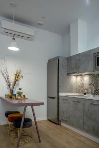 cocina con mesa y nevera en Apartamentos Turísticos Moret11-1A, en Cáceres