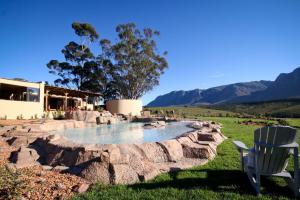 a rock pool in a yard with a chair at Oudebosch Guest Farm in Riversdale