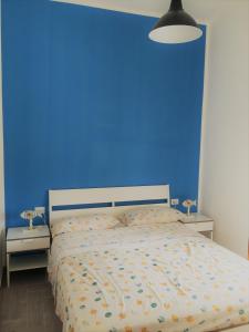 una camera blu con un letto e una parete blu di Il mare in casa a Cariati