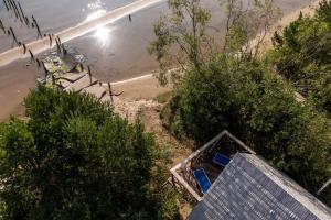 - une vue sur la plage avec une maison et des arbres dans l'établissement Viesu nams Melnsils, à Melnsils