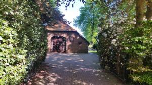 an entrance to a stone building with a hedge at Ferienwohnung Gartenblick in Westerstede