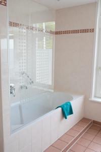 a white bathroom with a tub and a window at Het Rechthuis in Uithoorn