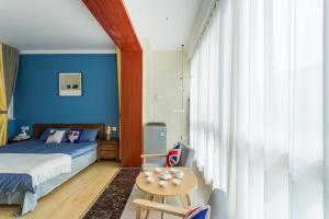 Un dormitorio con paredes azules y una cama y una mesa. en 【locals】Taian Taishan District Baolongcity Square, en Tai'an