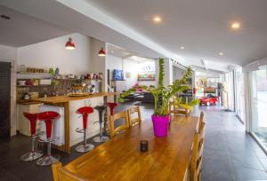 a dining room with a wooden table and red stools at LES TRESORS DE LIZZIE in Coutras