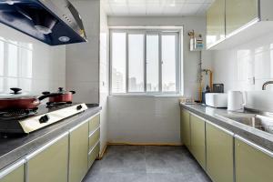 eine Küche mit Spüle und Herd oberen Backofen in der Unterkunft Xi 'an lianhu district · kaiyuanmen · Luke boutique apartment ·00184770 in Xi'an + 17 Fotos