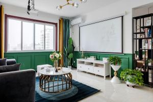 ein Wohnzimmer mit grünen Wänden und einem großen Bildschirm in der Unterkunft Xi 'an lianhu district · kaiyuanmen · Luke boutique apartment ·00184770 in Xi'an
