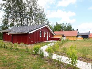 una casa roja con techo negro en 6 person holiday home in GROEMITZ, en Grömitz