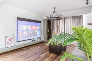 un soggiorno con una grande TV a schermo piatto di Qingdao Shibei·Qingdao Carrefour· a Qingdao
