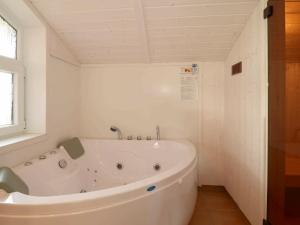 baño con bañera blanca y ventana en 6 person holiday home in GROEMITZ, en Grömitz