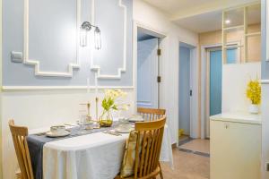 a dining room with a white table and chairs at Zhengzhou Erqi · Erqi Wanda Complex · in Zhengzhou
