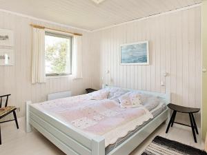 a white bedroom with a bed and a window at Holiday Home Sitkagranvej in Lihme