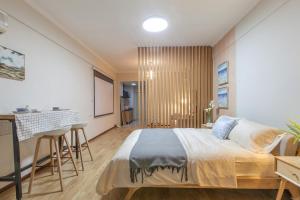 1 dormitorio con 1 cama grande y escritorio en [Roader] Wuhan Jiang'an District·Hong Kong Road, en Wuhan