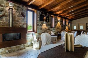 a restaurant with white chairs and a stone wall at Hotel Villa Venus Resort & SPA in Atena Lucana
