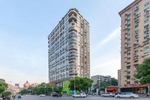 a tall building on a city street with cars at [Roader] Wuhan Jiang'an District·Hong Kong Road in Wuhan