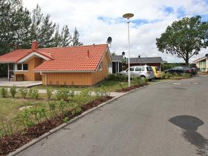 una casa con techo rojo en una calle en 6 person holiday home in GROEMITZ, en Grömitz