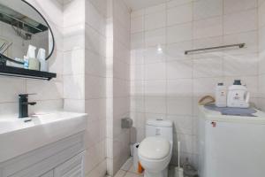 a white bathroom with a toilet and a sink at [Roader] Wuhan Jiang'an District·Hong Kong Road in Wuhan