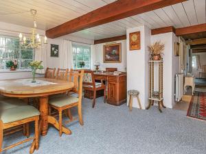 a dining room with a table and chairs and a desk at 6 person holiday home in L s in Læsø