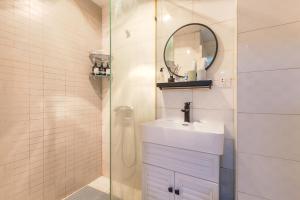 un bagno con lavandino e doccia con specchio di [Roader] Wuhan Jiang'an District, Hong Kong Road a Wuhan