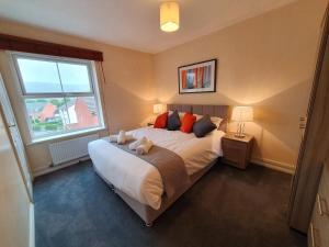 ein Schlafzimmer mit einem Bett mit zwei Stofftieren darauf in der Unterkunft Perry House, Long Ashton, Bristol by Cliftonvalley Apartments in Bristol