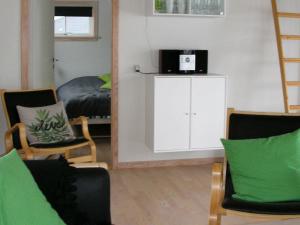 グドイェムにある6 person holiday home in Gudhjemのリビングルーム(椅子、鏡、ベッド付)