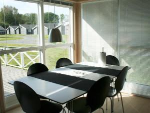 グドイェムにある6 person holiday home in Gudhjemの窓のある部屋(テーブル、椅子付)