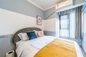 a bedroom with a large bed and a window at Zhengzhou Erqi · Erqi Wanda Complex · in Zhengzhou