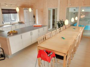 una cocina con una mesa de madera larga y sillas en 18 person holiday home in Tranek r, en Hou