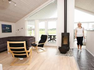 a woman standing in a living room with a fireplace at 9 person holiday home in Brovst in Brovst