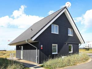 een zwart huis met een gambrel dak bij 8 person holiday home in Wendtorf in Stein